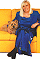 Wendy Richard, in blue dress, sitting on a yellow sofa