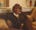 Wendy Richard, dressed in a brown tracksuit, sitting on the sofa in her flat, 
				  circa 1989.